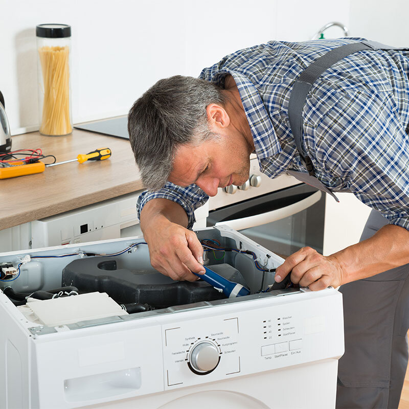 Technician repairing washing machine at home – 24x7 repair service